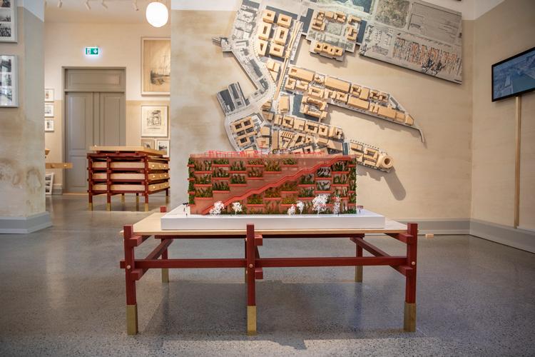 En model af Jaja Architects røde parkeringshus med motionsplads på toppen står foran en model af det nuværende Nordhavn, hvor p-huset er opført. Udstillingen og møblerne er tegnet af JAC Studios. Foto: By & Havn/ Peter Sørensen