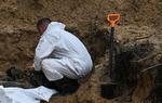    En ukrainsk tekniker undersøger et lig i en massekrav i Ukraine torsdag. Disse fund vil styrke presset på Rusland og krav om at stille præsident Putin for Den Internationale Straffedomstol - som hverken Rusland eller USA anerkender. Foto: Juan Barreto/Ritzau Scanpix