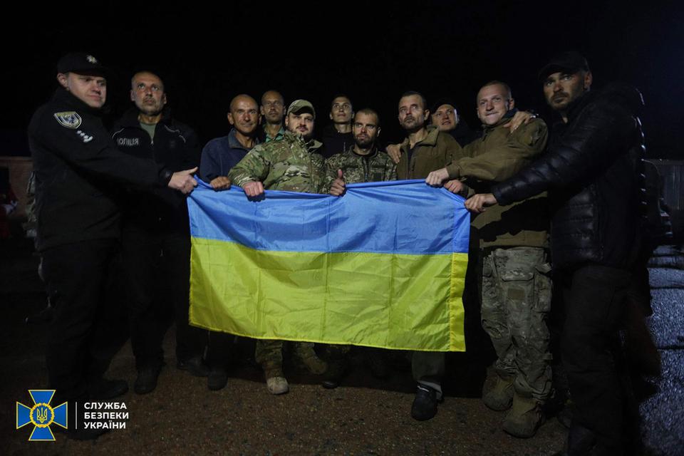 En gruppe ukrainske krigsfanger med deres flag efter frigivelsen. Foto: Handout/Ritzau Scanpix