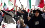  Iranske kvinder har ledt an i protesterne mod præstestyret i Iran. Her er de to kvinder, der bærer billeder af den religiøse leder Khamenei.  Foto: -/Ritzau Scanpix