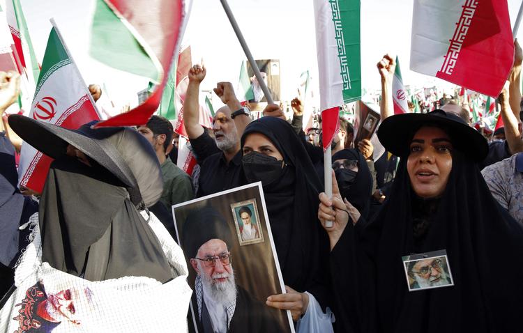  Iranske kvinder har ledt an i protesterne mod præstestyret i Iran. Her er de to kvinder, der bærer billeder af den religiøse leder Khamenei.  Foto: -/Ritzau Scanpix