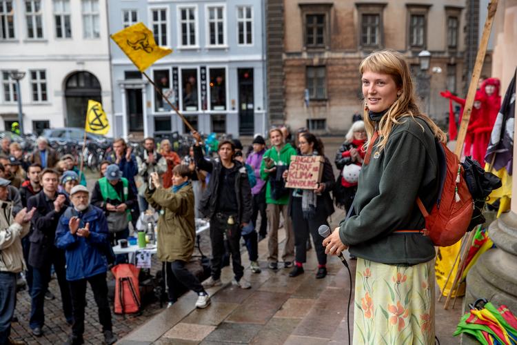 19-årige 'Rod' foran Københavns Byret. I baggrunden hænger gule flag fra Extinction Rebellion (til venstre) og søsterorganisationen Animal Rebellion (til højre). Foto: Jacob Ehrbahn