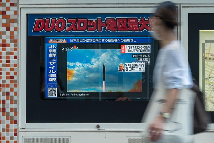 En kvinde går forbi en tv-skærm i Tokyo, som viser nyhederne om det nordkoreanske missil, der landede i havet. Foto: Richard A. Brooks/Ritzau Scanpix