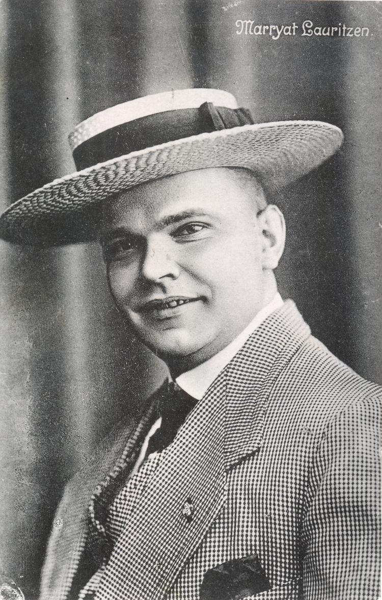 PR-foto af den muntre komiker og visesanger som 30-årig i 1914. To små hæfter indeholdt flere af hans vitser. Fotos: Erhvervsarkivets samling af portrætter. Rigsarkivet.

  