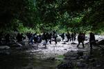 Migranter krydser Acandi-floden på deres vej gennem Darién-junglen, som forbinder Panama og Colombia. I alt har 151.582 migranter i løbet af i år taget turen, der har USA som endemål. Foto: Fernando Vergara/Ritzau Scanpix