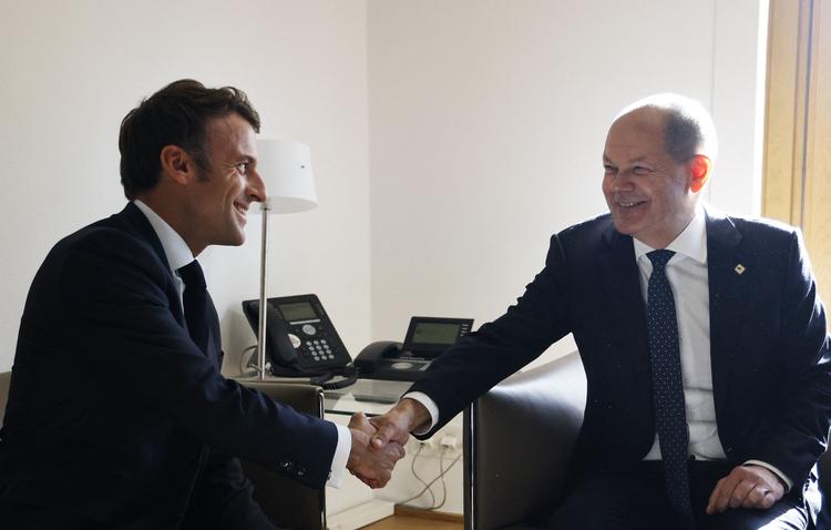 Den franske præsident Macron og den tyske kansler Scholz prøver at holde smilene brede, da de mødes til tomandssnak under EU-topmødet i Bruxelles, hvor de begge lige har langet ud efter hinanden Foto: Ludovic Marin/Ritzau Scanpix