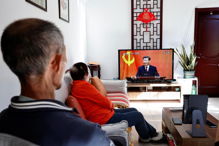Kinesiske pensionister ser til, mens generalsekretær Xi Jinping søndag erklærede, at han fortsætter som Kinas ubestridte leder for en tredje valgperiode. Foto: Thomas Peter/Ritzau Scanpix