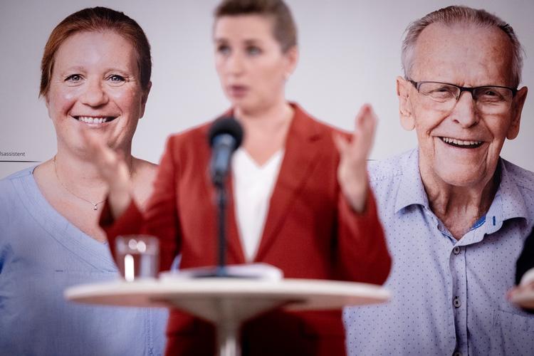 Arne-pensionen har været den socialdemokratiske juvel. Nu gælder det sosu-assistenterne Pia og Ernst – Pia ses her bag Mette Frederiksen, mens Ernst ikke er kommet med på billedet. Det er i stedet en unavngiven ældre mand, som Pia passer.  Foto: Mads Nissen