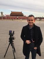 Indtil dette forår dækkede Philip Khokhar Kina for DR. Her står han på Den Himmelske Freds Plads i Beijing med Maos store portræt hængende over indgangen til Den Forbudte By i baggrunden.   Foto: PR