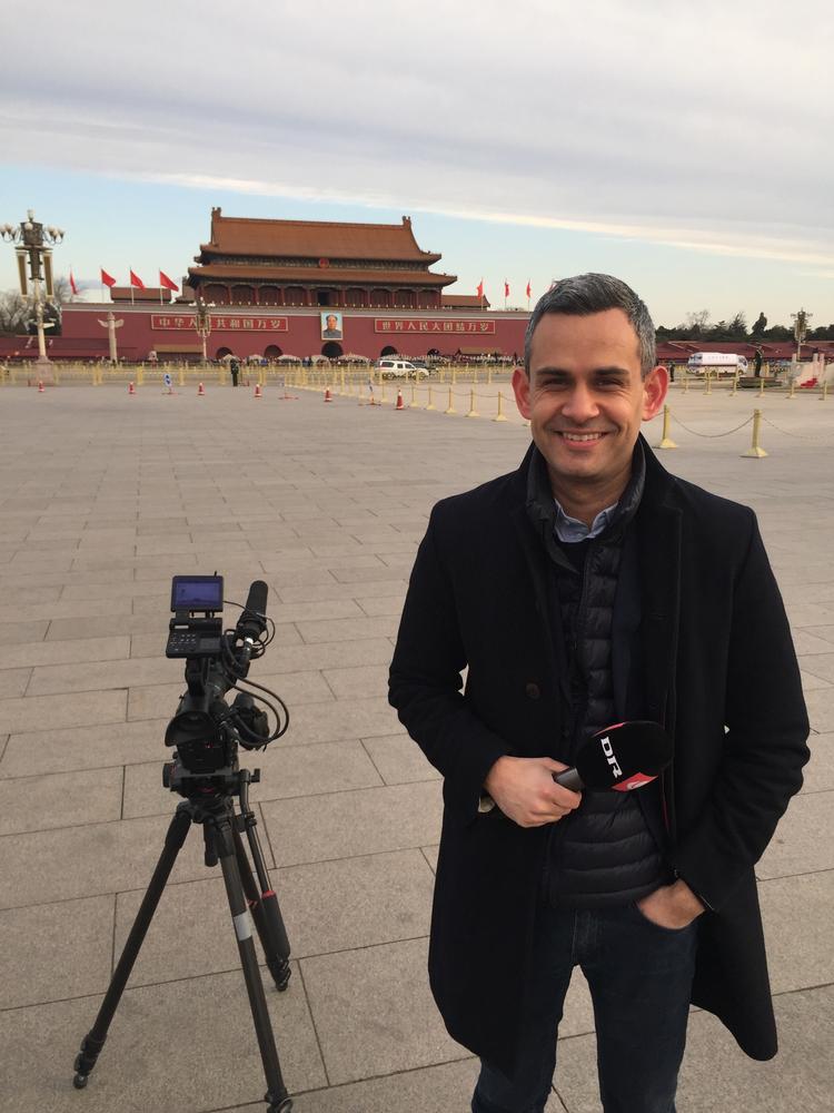 Indtil dette forår dækkede Philip Khokhar Kina for DR. Her står han på Den Himmelske Freds Plads i Beijing med Maos store portræt hængende over indgangen til Den Forbudte By i baggrunden.   Foto: PR