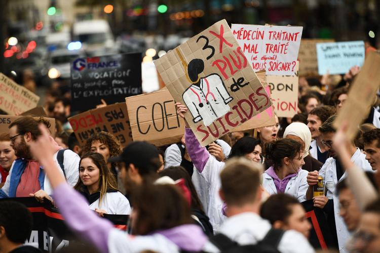    'Tre gange flere selvmord', står der på skiltet, som medicinstuderende bar under en demonstration tidligere på måneden mod en reform af de deres studier. Antallet af selvmord blandt unge stiger voldsom, og flere og flere lukker sig inde hos sig selv.   Foto: Christophe Archambault/Ritzau Scanpix
