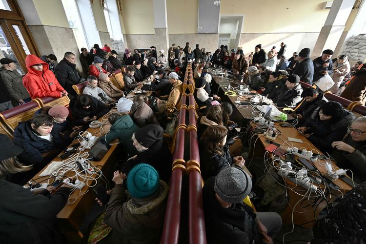 Strømmen er forsvundet mange steder og beboere i Kherson oplader deres telefoner i byens stationsbygning.  Foto: Genya Savilov/Ritzau Scanpix