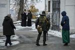 Ortodokse præster betragter en ukrainsk soldat. Billedet er taget i går i Kyiv.  Foto: Stringer/Ritzau Scanpix