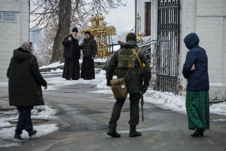 Ortodokse præster betragter en ukrainsk soldat. Billedet er taget i går i Kyiv.  Foto: Stringer/Ritzau Scanpix