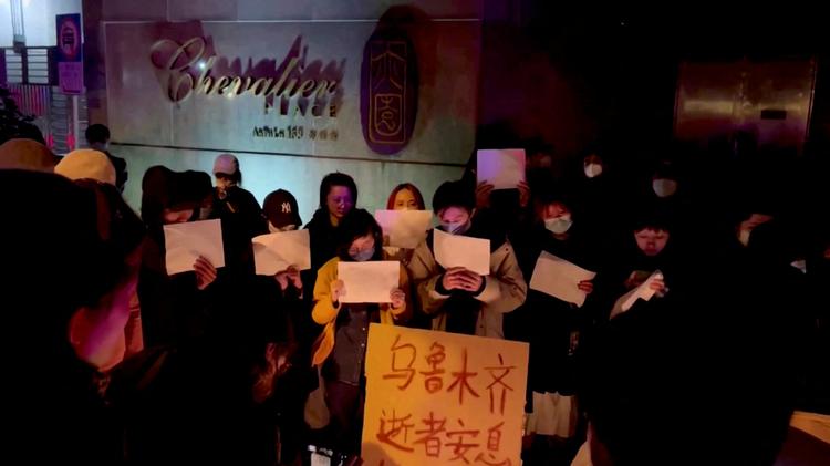 Borgere i Shanghai tændte lørdag nat lys for ofrene i en højhusbrand i det vestlige Kina. Dørene til højhuset var angivelig låst på grund en coronakarantæne, så indbyggerne ikke kunne slippe ud. Foto: Gao Ming/Ritzau Scanpix