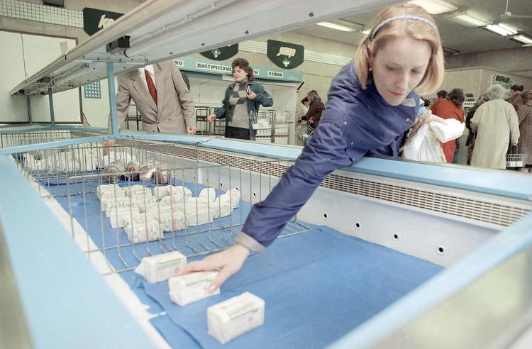 Manglen på varer var et tilbagevendende problem i det gamle Sovjet. Her er det en kvinde, der rækker ud efter en pakke smør i et supermarked i Moskva i 1990. Foto: Alexander Zemlianichenko/Ritzau Scanpix