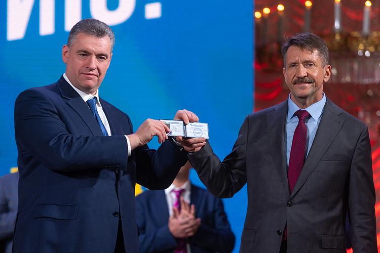Leonid Slutsky, lederen af LDPR, og Viktor Bout står med den tidligere fanges medlemskort af det ultranationalistiske parti.  Foto: Aleksandr Sivov/Ritzau Scanpix