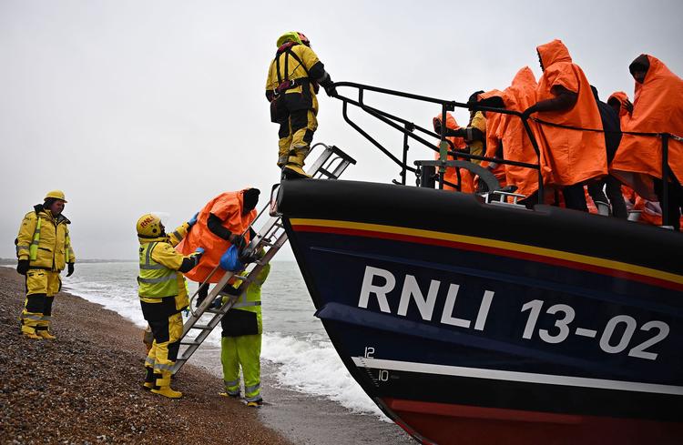 Asylansøgere, der har krydset Den Engelske Kanal, forlader den redningsbåd, som samslede dem op. Billedet er taget i Dungeness i det sydøstlige England 9. december.  Foto: Ben Stansall/Ritzau Scanpix