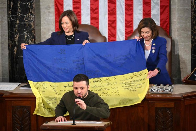 Ukraines præsident Volodymyr Zelenskyj holdt natten til torsdag tale i Kongressen i USA og overbragte vicepræsident Kamala Harris (bagest tv.) og formanden for Repræsentanternes Hus, Nancy Pelosi (bagest th.) et ukrainsk flag fra slagmarken, hvor soldater havde sat deres underskrift. Foto: Mandel Ngan/Ritzau Scanpix