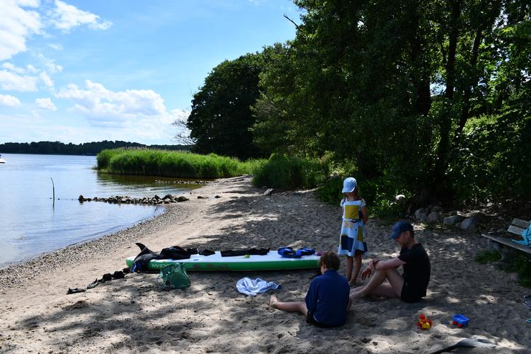 Vi hygger på landsbyens lille strand med SUP-board og strandlejetøj, som vi har lånt af vores boligbytte-familie. Ofte har vi stranden helt for os selv. 