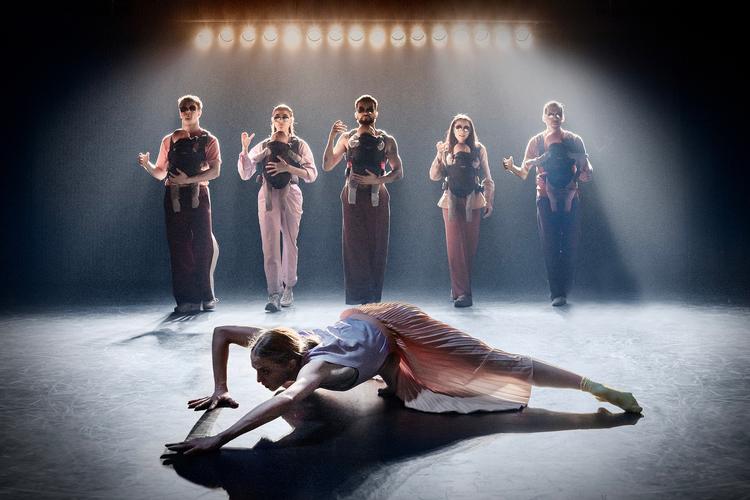 Som en undermåler må den barnløse kvinde (Astrid Elbo) krybe over scenen, når den funky coole barselsbande kommer anstigende med trofæbabyer på maven. Foto: Camilla Winther 