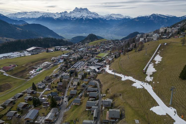 Skiløberne i schweiziske Leysin kan lige akkurat finde plads på en smal stribe af kunstsne.     Foto: Denis Balibouse/Ritzau Scanpix