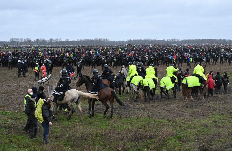    Ridende politi forsøger at holde tusinder af demonstranter på afstand af den store brunkulsmine ved Lützerath. Politiet er i gang med at fjerne besættere og aktivister fra landsbyen.   Foto: Ina Fassbender/Ritzau Scanpix