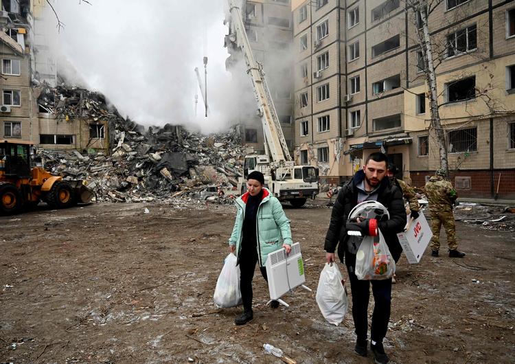    Beboere bærer ejendele væk fra en ødelagt beboelsesejendom i Dnipro efter et russisk missilangreb, som lørdag kostede 23 civile livet. Foto: Sergei Chuzavkov/Ritzau Scanpix