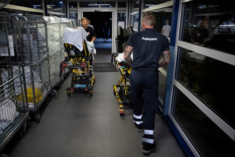 En nat i august ankommer en ambulanceredder med en patient til akutmodtagelsen på Bispebjerg Hospital, mens en kollega netop har afleveret én og er på vej ud i ambulancen med tom båre. Arkivfoto Finn Frandsen