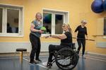 Da Cathrine Guldberg i kørestolen fik fysisk træning af en gående instruktør, tænkte hun, at det ville være mere effektivt, hvis hun selv tog en fitnessuddannelse. Så nu laver hun siddende træning med andre i en lignende situation. Foto: Christian Falck Wolff
