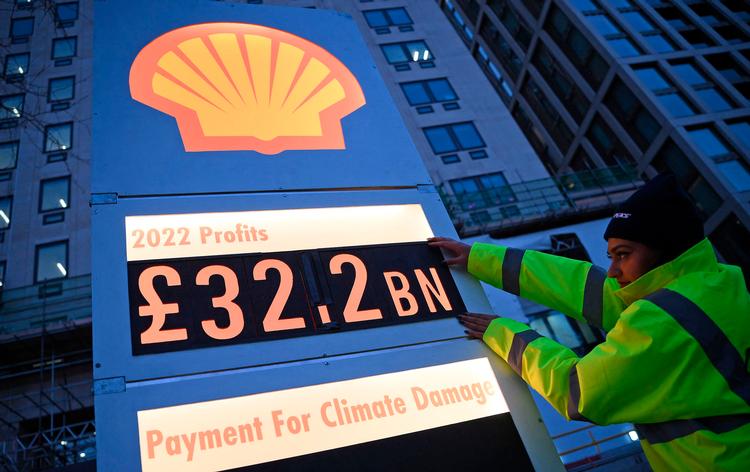 Aktivister fra Greenpeace opsatte i London et skilt, der skulle ligne et benzintank-skilt, i protest mod Shells rekordoverskud.  Foto: Daniel Leal/Ritzau Scanpix
