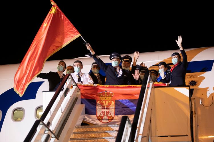    Crew members wave Chinese and Serbian flags after medical experts from China arrived at the Nikola Tesla airport with medical supplies to help country's fight against coronavirus (COVID-19) outbrake in Belgrade, Serbia, March 21, 2020. REUTERS/Marko Djurica   Foto: Marko Djurica/Ritzau Scanpix