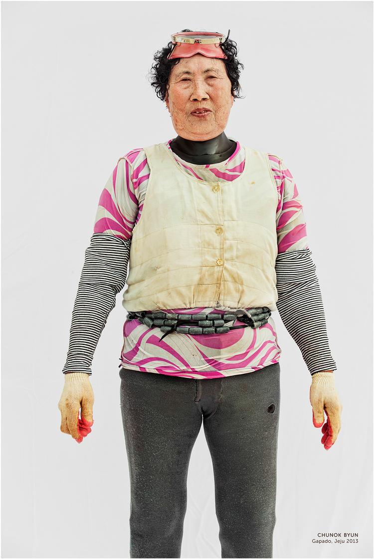 Flere af kvinderne bærer fine skjorter uden på dykkerdragten. De er blevet fotograferet, kort efter at de er kommet op af havet. Vandet drypper stadig fra dem, og de ser udmattede ud, men deres øjne er spillevende. Her er det Chunok Byun.  Foto: Hyung S. Kim 