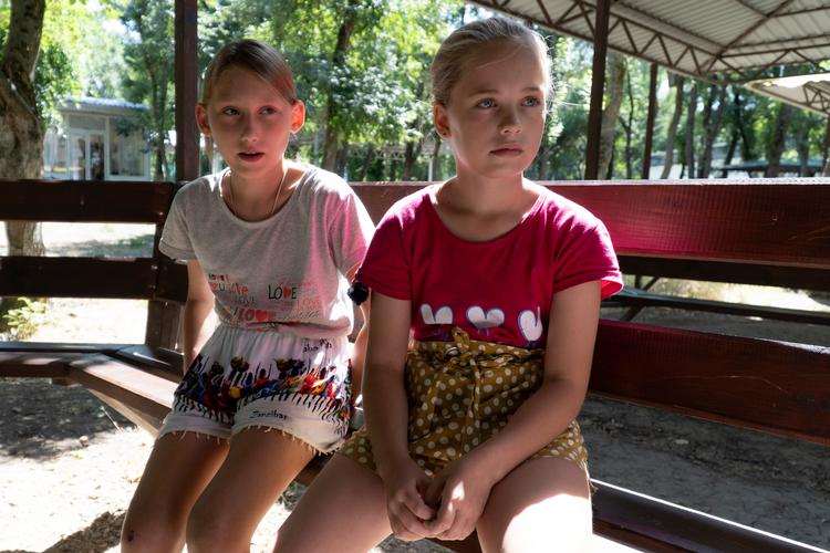 Allerede i sommer var der forlydender om, at forældreløse, ukrainske børn kom i pleje hos russiske familier. Nyhedsbureauet AP mødte pigerne Olesya Lyadchenko (tv.) og Yaroslava Rogachyova (th.) i en lejr i Zolotaya Kosa i Rostov-området i det sydvestlige Rusland i juli. Yaroslava fortalte her AP, at hun ville savne Donetsk, men at hun havde fået et godt indtryk af sin nye plejefamilie under et videomøde. Foto: Uncredited/Ritzau Scanpix