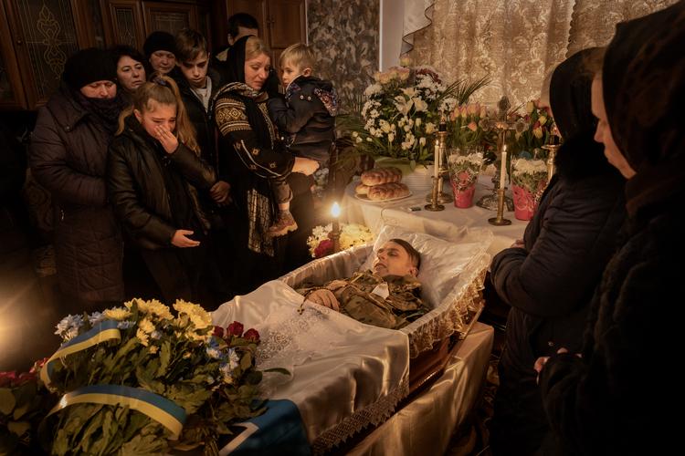 En kold martsdag i 2022 sagde ukrainske Roman Ruschyshyns familie farvel - hans kone Oksana med den yngste søn, Nazar, og ved siden af hende sønnen Roman og datteren Anastasia. Deres far kæmpede i Luhansk-regionen, da han blev dræbt af russiske styrker.  Foto: Mads Nissen/POLITIKEN