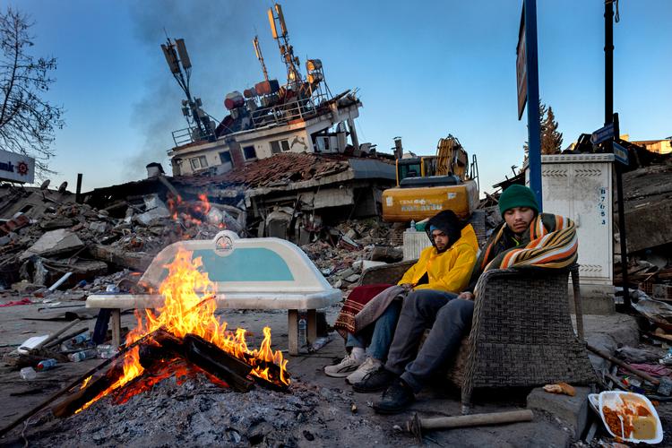 I Kahramanmaraş, som var jordskælvets epicenter, sidder brødrene Salahatin og Alazahir, ved en sammenstyrtet bygning hvor deres forældre og to andre familiemedlemmer har ligget begravet i tre dage.   Foto: Jacob Ehrbahn