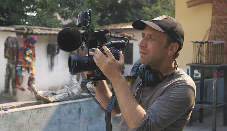 Vel ankommet til storbyen de lokale kalder Kin, finder den franske udgave af Armel Hostiou sit filmkamera frem. Still 