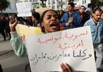     En kvinde bærer et banner med indskriften: 'Feminist, tuneser, afrikaner. Alle mænd og kvinder er migranter' på en protestdemonstration mod præsident Saïeds angreb på migranter. i  Foto: Jihed Abidellaoui/Ritzau Scanpix