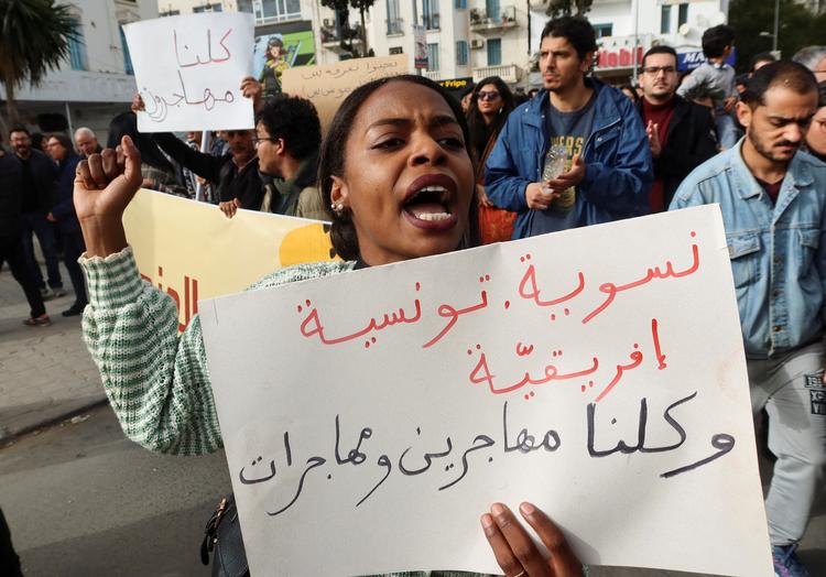     En kvinde bærer et banner med indskriften: 'Feminist, tuneser, afrikaner. Alle mænd og kvinder er migranter' på en protestdemonstration mod præsident Saïeds angreb på migranter. i  Foto: Jihed Abidellaoui/Ritzau Scanpix