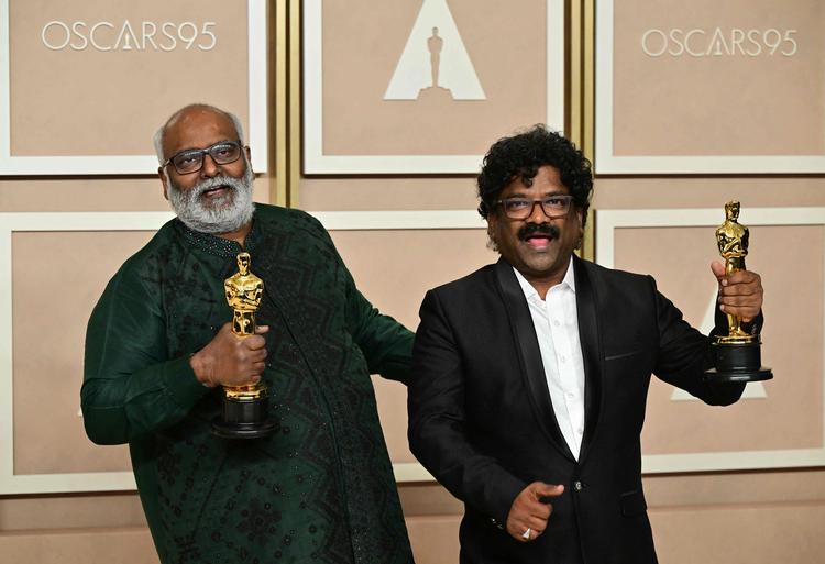 Sangskriver M.M. Keeravaani (t.v.) og sanger Chanrabose løfter Oscar-statuetterne for deres sang 'Naatu Naatu'. Foto: Frederic J. Brown/Ritzau Scanpix