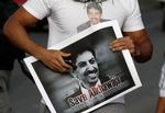En demonstrant i Bahrain iklædt en t-shirt og med en plakat i hånden med billeder af Abdulhadi al-Khawaja i 2012. Foto: Hasan Jamali/Ritzau Scanpix