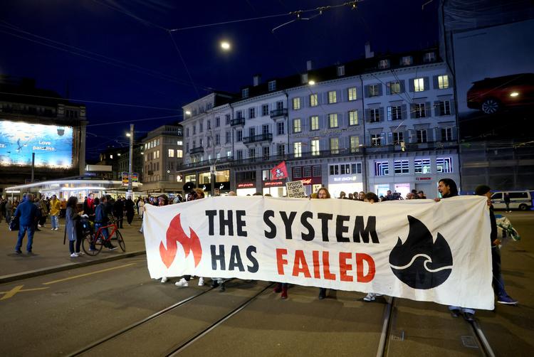 Virker kapitalismen? Demonstranter i Zürich protesterer mod storbanken UBS' overtagelse af den forliste rival Credit Suisse. 'Systemet har fejlet' lyder det på banneret.  Foto: Denis Balibouse/Ritzau Scanpix