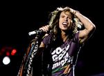 Steven Tyler i de sædvanligt flagrende gevandter og tørklædet bundet til mikrofonstativet i spidsen for Aerosmith ved en koncert i Randers. Foto: Claus Bonnerup