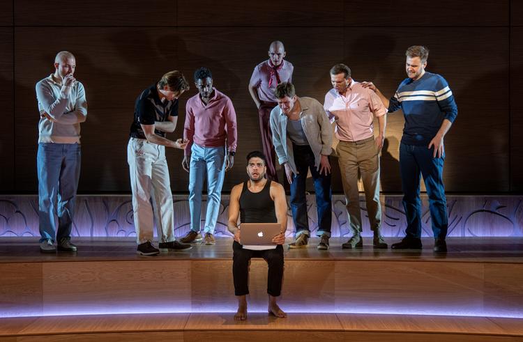 Replikkerne i ’Arven’ flyver så sømløst, at de mange mænd på scenen bliver som én krop. Dramatikeren Toby i front spilles af Alvin Olid Bursøe. Foto:  Palle Steen Christensen