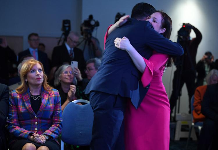 Humza Yousaf får et kram af sin tabende udfordrer, Kate Forbes, som kom med hårde anklager mod ham under kampen om at blive ny skotsk førsteminister. Til venstre kigger Ash Regan, som også deltog i kapløbet, på.  Foto: Andy Buchanan/Ritzau Scanpix