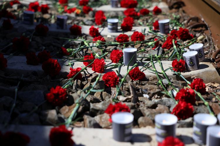 Blomster og lys ved togspor for at markere, at det er 80 år siden, at de første jøder blev deporteret fra Thessaloniki i Grækenland til Auschwitz. Foto: Alexandros Avramidis/Ritzau Scanpix