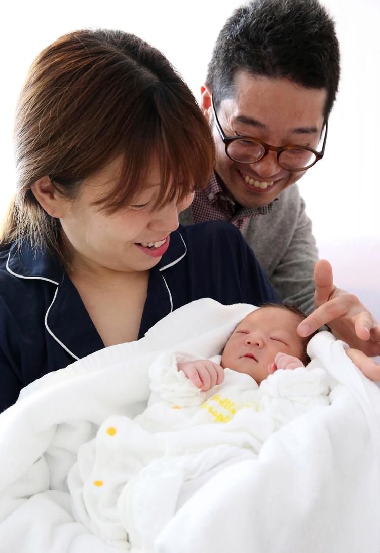 Det japanske par Makiko Nakamura (tv.) og Kenichi glæder sig over deres baby, Soma.   Foto: Takuya Yoshino/Ritzau Scanpix