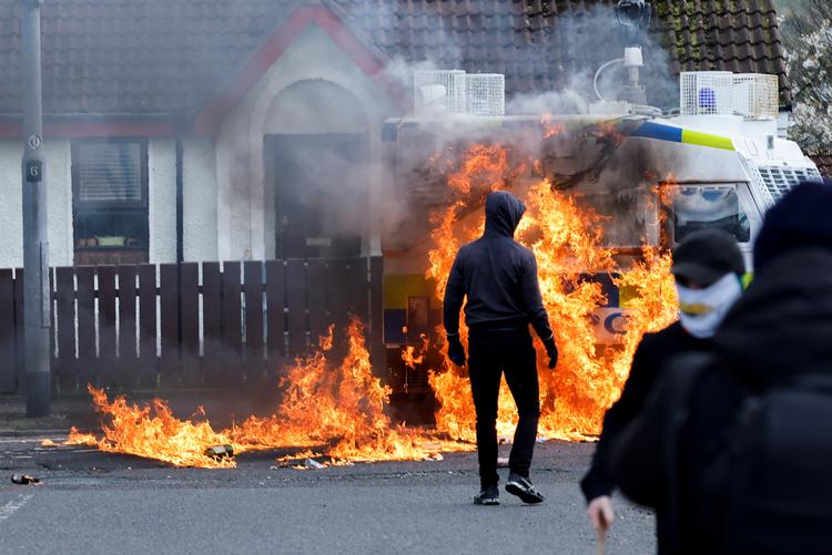 En politibil blev mandag stukket i brand af republikanske demonstranter i Londonderry i Nordirland, der marcherede på 25-års-dagen for fredsaftalen.  Foto: Clodagh Kilcoyne/Ritzau Scanpix