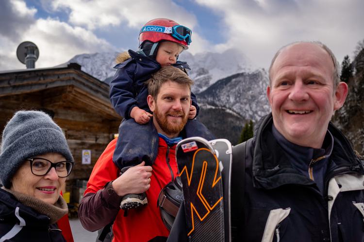 Per sidder hos sin far Rune Homøe-Sørensen, mens bedsteforældrene står på hver side, Lotte og Preben Homøe udenfor den hytte, hvor de lige har fået frokost. Foto: Per Munch