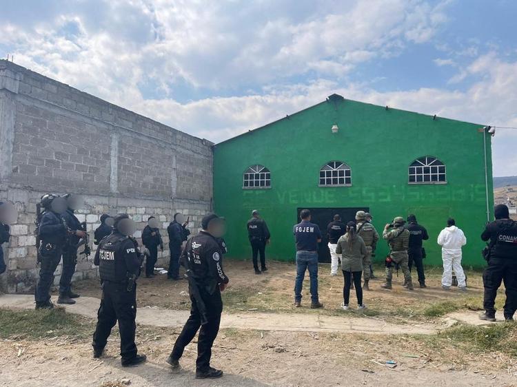 Sikkerhedspersonale er samlet uden for et varehus i Tenango del Valle i Mexico, hvor der blev fundet en massegrav i januar i år.  Foto: Attorney General Of The State Of/Ritzau Scanpix